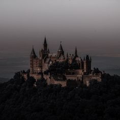 an old castle sits on top of a hill in the middle of the night time