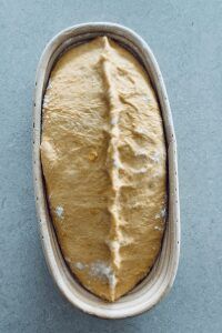 an uncooked loaf of bread sitting in a pan on top of a table