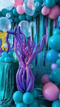 balloons and streamers are hanging from the ceiling in front of an understated table