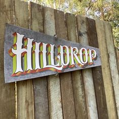 a wooden fence with a sign on it that says hillbrop in white lettering