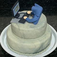 there is a cake that has a computer on it with a person sitting at the keyboard