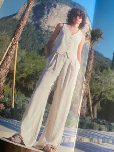 an open magazine with a woman in white clothing on the cover and palm trees behind her