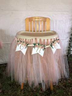 a chair with a tulle skirt on it and two tags hanging from the back