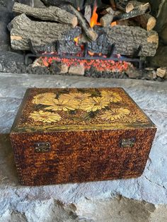 a wooden box sitting on top of a stone floor next to an open fire place