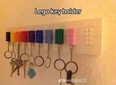 a row of lego key chains hanging on a white wall with keys attached to it