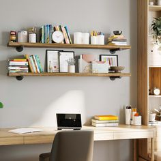 a laptop computer sitting on top of a wooden desk next to a shelf filled with books