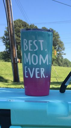 a cup with the words best mom ever on it sitting on top of a blue cooler