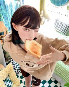 a woman holding a piece of bread up to her mouth