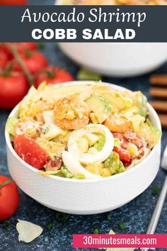 a white bowl filled with corn salad next to tomatoes and other vegetables on the table