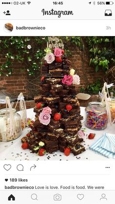 a cake that is on top of a table with flowers and strawberries in it