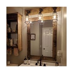 a bathroom mirror with lights hanging above it