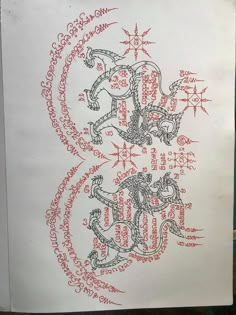 an image of a drawing on paper with writing in the middle and two dragon heads