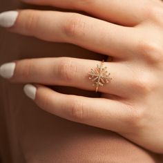 a woman's hand wearing a gold ring with a star design on the middle