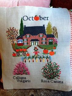 a cross stitch pillow with the words october on it