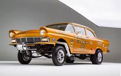 an old yellow truck is parked in a studio area with grey walls and white flooring