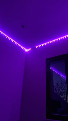 purple lights are on the ceiling in a room with a mirror and window sill