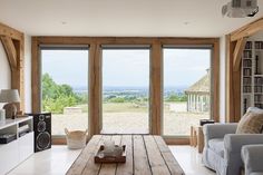 a living room filled with furniture next to large sliding glass doors that look out onto the countryside