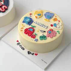 two birthday cakes on top of each other, one decorated with fondant and the other decorated with icing