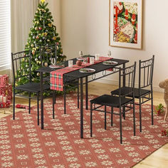 a dining room table with chairs and a christmas tree in the background