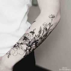 a woman's arm with flowers and leaves tattooed on the left side of her arm