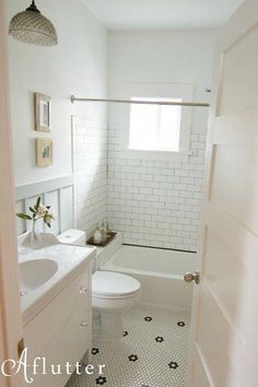 a white bathroom with black and white floor tiles