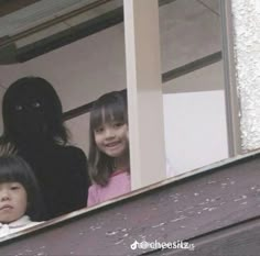 two children looking out an open window with a black cat on the ledge behind them