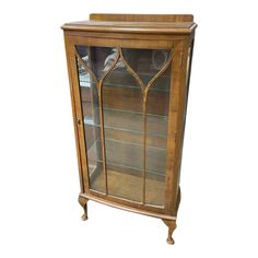 an antique display cabinet with glass doors and wood trimmings on the top shelf