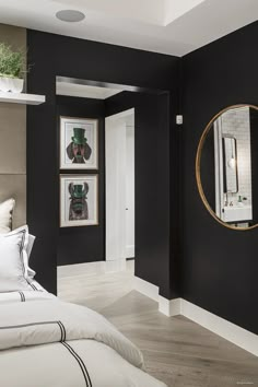 a bedroom with black walls and white bedding