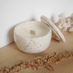 a white bowl sitting on top of a wooden table next to a piece of rope