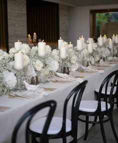 a long table with white flowers and candles