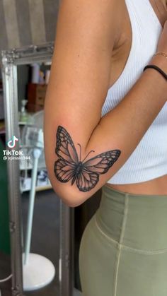 a woman with a butterfly tattoo on her arm