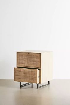 an end table with two drawers on each side and a white wall in the background