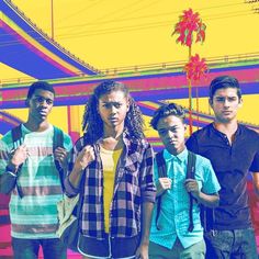 a group of young people standing next to each other in front of a colorful background