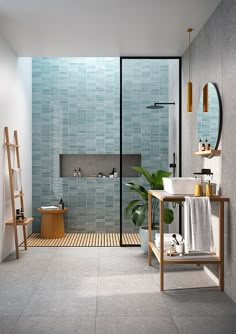 a bathroom with blue tiles and wooden flooring next to a bathtub, shower head, and sink