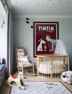 a baby's room with rocking chairs and a poster on the wall