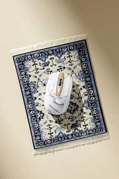 a computer mouse sitting on top of a blue and white rug with an intricate design