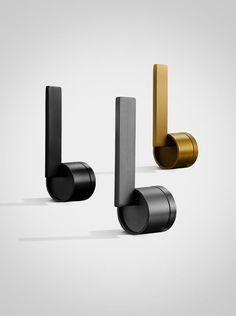 three black and gold door handles on a white background, one with a metal handle