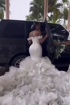 a woman in a wedding dress getting out of a limo