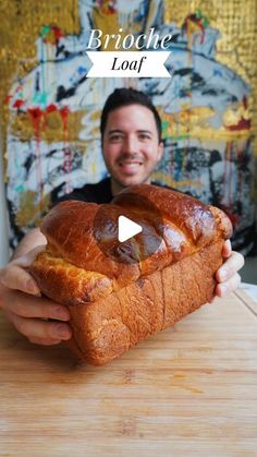 a man holding a loaf of bread on top of a wooden cutting board with the words brioche loaf