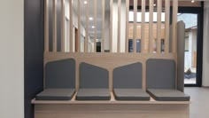 a waiting area with four seats and a wooden divider on the wall behind it