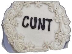 a white cake with the word cut in black icing on it's side