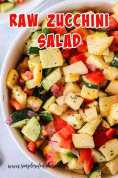 a white bowl filled with chopped vegetables and the words raw zucchini salad