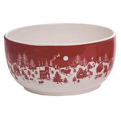 a red and white bowl with a christmas scene on the side, in front of a white background