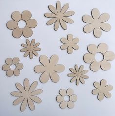 several wooden flowers are arranged on a white surface