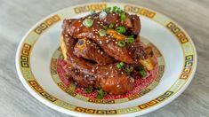 a white plate topped with meat covered in sesame seeds