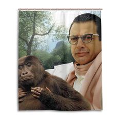 a man with glasses holding a monkey in front of a shower curtain that has an image of him on it