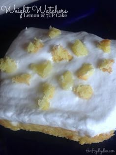 a piece of cake with white frosting and yellow crumbs