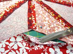 a pair of scissors sitting on top of a red and white flowered fabric with flowers