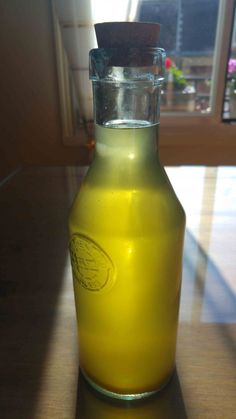 a yellow glass bottle sitting on top of a wooden table