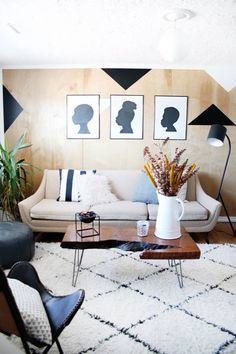 a living room filled with furniture and pictures on the wall above it's coffee table